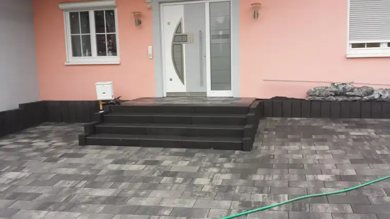 Eingangstreppe mit Blockstufen vor einem Haus, davor neue Pflasterfläche
