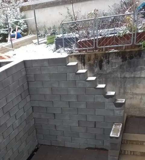 Hof nachher: Platten verlegt vor der fertigen Mauer mit Treppe
