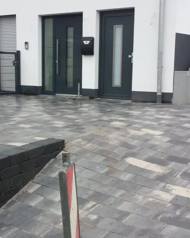 Vorplatz nachher: fertig gepflastert in grau changierendem Pflaster
